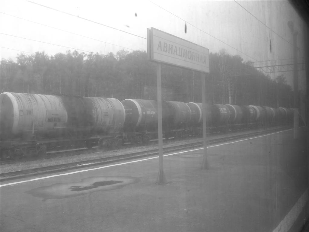 Au travers des vitres quasi opaques de salet, on voit plusieurs trains de marchandises trs rouills.