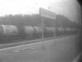 Au travers des vitres quasi opaques de salet, on voit plusieurs trains de marchandises trs rouills.